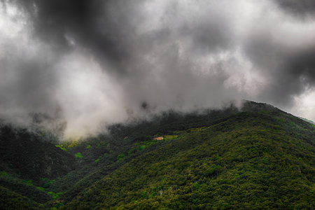 General view of the mountain with clouds and isolated houseの写真素材