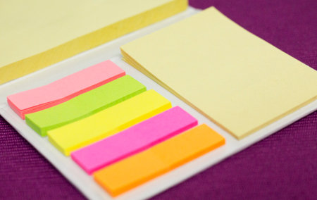 Colorful adhesive sticky notes on the purple table in the office.