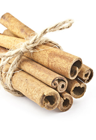 Tied with thread cinnamon sticks on a white background. Macro photography.の写真素材