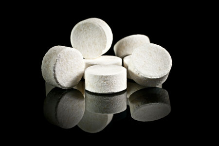 On a black background a lot of pills assembled stack.