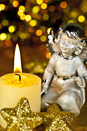 Christmas Angel staring at a burning candleの写真素材