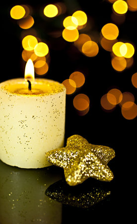 Candle with a star on a black background, back background Bokeh lights.の写真素材