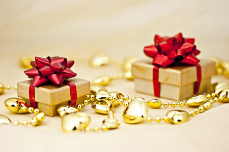 On the golden background gift box with a golden heart strings.の写真素材