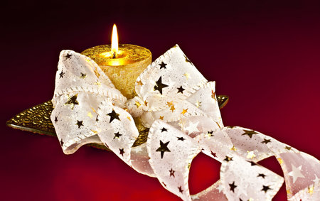 Christmas Decor, a burning candle gift with Bantu on a red background.の写真素材