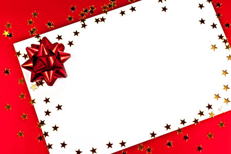 On a red background white greeting card with golden stars.の写真素材