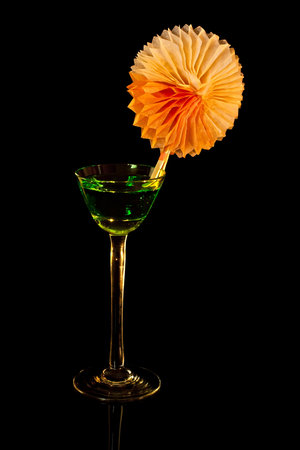On black cocktail glass with vermouth and green decor.の写真素材