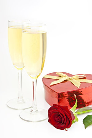On white champagne glasses, gift box heart in the form of a red rose.の写真素材