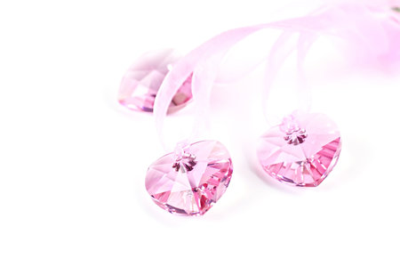 Three pink crystal hearts on a white background.の写真素材