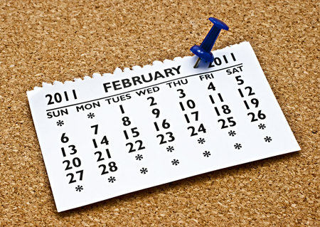 Pinned to the cork with a blue pin the month of February calendar page.の写真素材