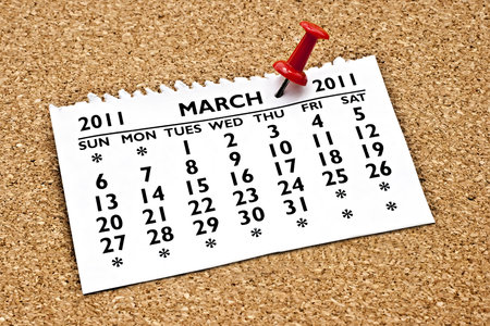 Pinned to the cork with a blue pin the month of March calendar page.の写真素材