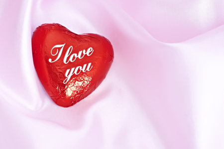 On a pink background,  one sweet hearts with the words I love you.の写真素材