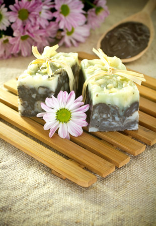 Natural soap, handmade. Pink flowers and spoon with cosmetic clay.の写真素材