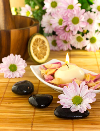 Spa treatment.Burning candle,  spa stones, dry lemon, pink flowers.の写真素材
