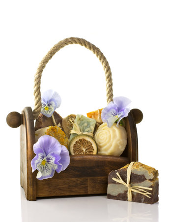 Composition of the basket full of handmade soap, isolated on white background.の写真素材