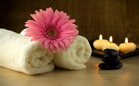 Towels and pink flower, candles and massage Stones in a Zen Spa.の写真素材