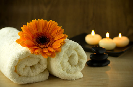Towels and orange flower, candles and massage Stones in a Zen Spa.の写真素材