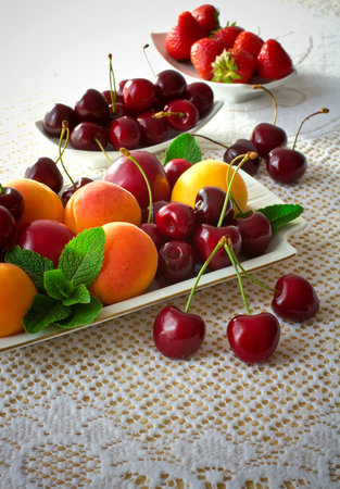 Plate with fruits, cherries, apricots, plums, strawberries and mint.の写真素材