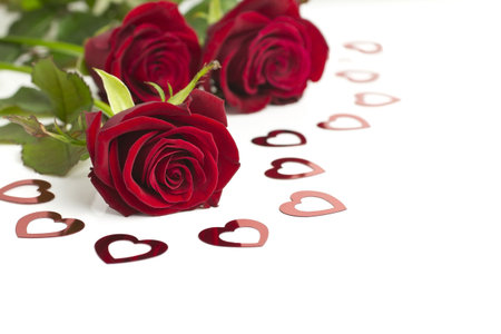 Three roses red with hearts on a white background.の写真素材