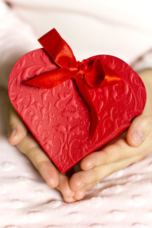 The hands of children in heart gift box.の写真素材