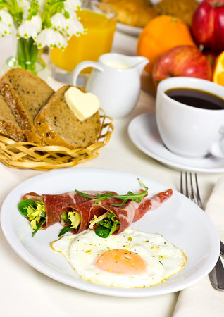 Breakfast, bread with a heart of butter, fried eggs with bacon and coffee の写真素材