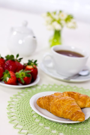 Tasty breakfast  Croissants with tea, and fresh  strawberries の写真素材