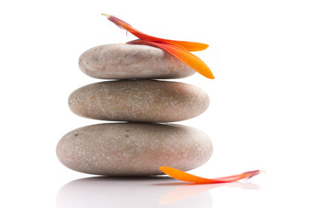 Spa stones and orange leaf, isolated on white background.の写真素材