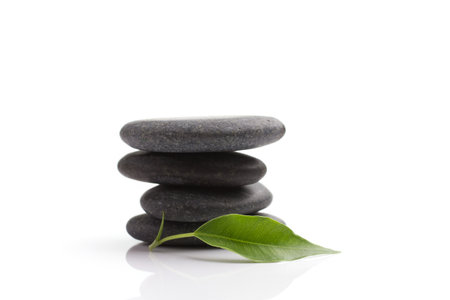 Spa stones and green leaf, isolated on white background.の写真素材