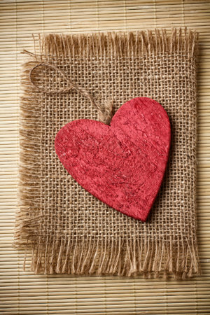 Red wooden heart on a linen cloth and wood background の写真素材