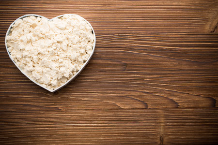 Soy on a wooden background, heart-shaped dish.の写真素材