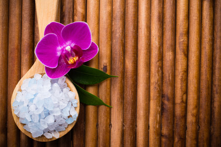 Sea salt on wooden spoon, purple orchid on wooden backgroundの写真素材