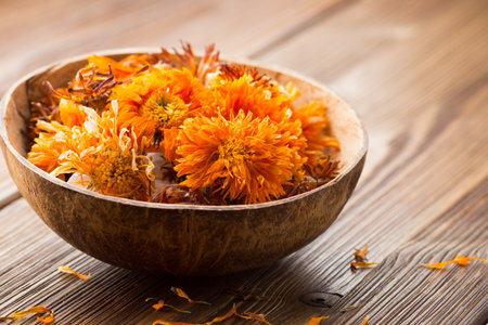 Homeopathic medicine, calendula dry flowers and wooden surface.の写真素材