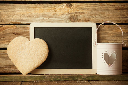 Heart of the cookies and blackboard,  wooden background.の写真素材