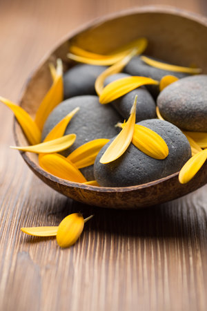 Gerbera flower petals and spa stones, wooden background.の写真素材