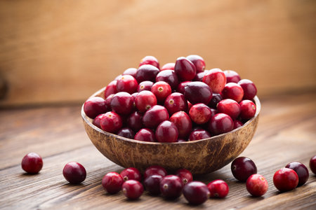 Cranberries in wooden bowl on wooden background.の写真素材