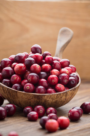 Cranberries in wooden bowl on wooden background.の写真素材