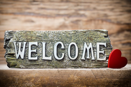 On the wood background of a plaque with an inscription welcome.の写真素材