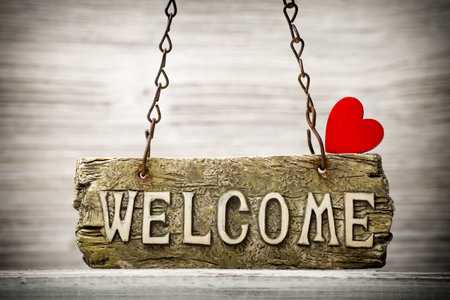 On the wood background of a plaque with an inscription welcome.の写真素材