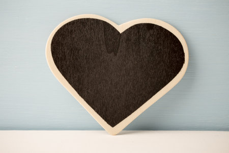 Board in the form of heart on a white wooden background.の写真素材