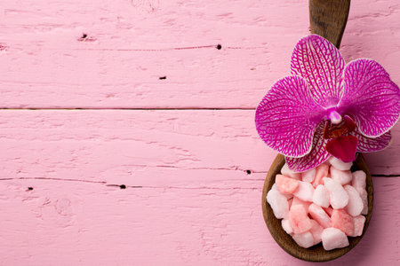 Sea salt wooden spoon on the pink orchid.の写真素材