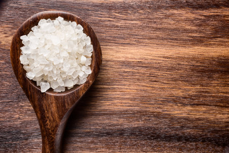 Sea salt wooden spoon on brown wooden background.の写真素材