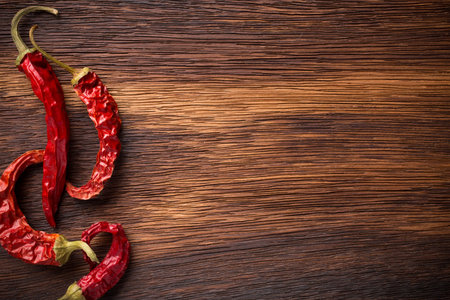 Red chili peppers on a wooden background. The menu background.