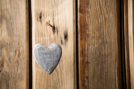 Heart hanging on nails, wooden texture background. Studio photo.の写真素材