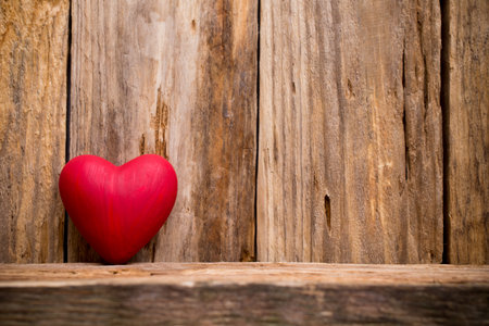 Heart on a wooden shelf. Wooden wall, studio photography.の写真素材