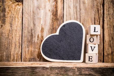 Written on wooden blocks love and red heart.の写真素材