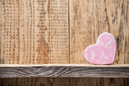 Heart on a wooden shelf. Wooden wall, studio photography.の写真素材