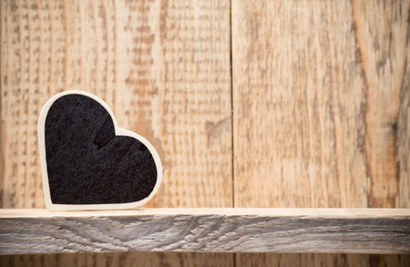 Heart on a wooden shelf. Wooden wall, studio photography.の写真素材