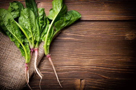 Spinach with roots on the wooden background.の写真素材