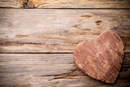 Heart on a wooden shelf. Wooden wall, studio photography.の写真素材