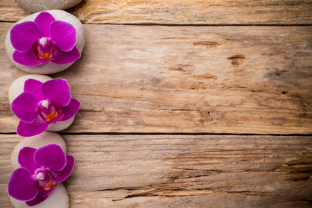 Orchids flowers on wooden background spa massage stones.の写真素材