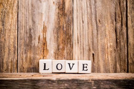Written on wooden blocks love and red heart.の写真素材